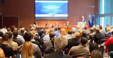 Audience listening to a speech at a convention.