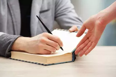 Author signing a book for a fan.