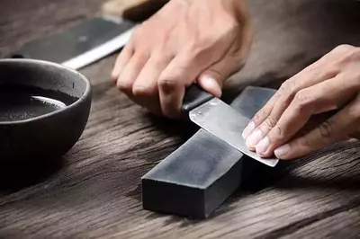 Sharpening a kinfe from Smoky Mountain Knife Works on a whetstone.