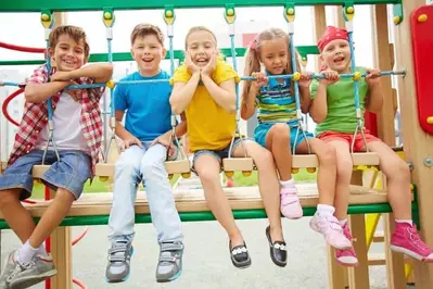 Kids riding together on a swing ride at a theme park
