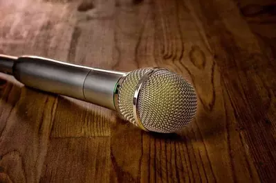 Microphone laying on a brown wooden table