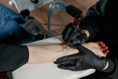 person giving a sun tattoo