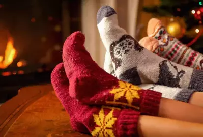 family with holiday socks in front of fire in a cabin
