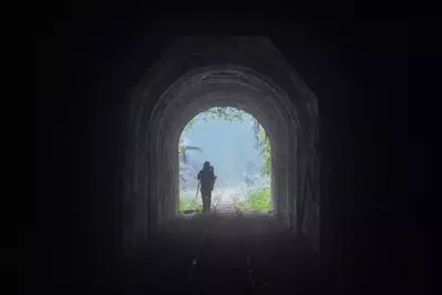 hiker walking through tunnel in the mountains