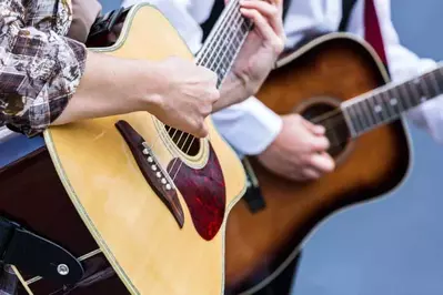 two people playing guitars