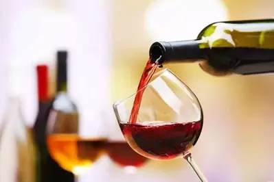 A glass of red wine being poured.