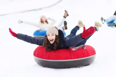 A young woman smiling while snow tubing at Ober Gatlinburg
