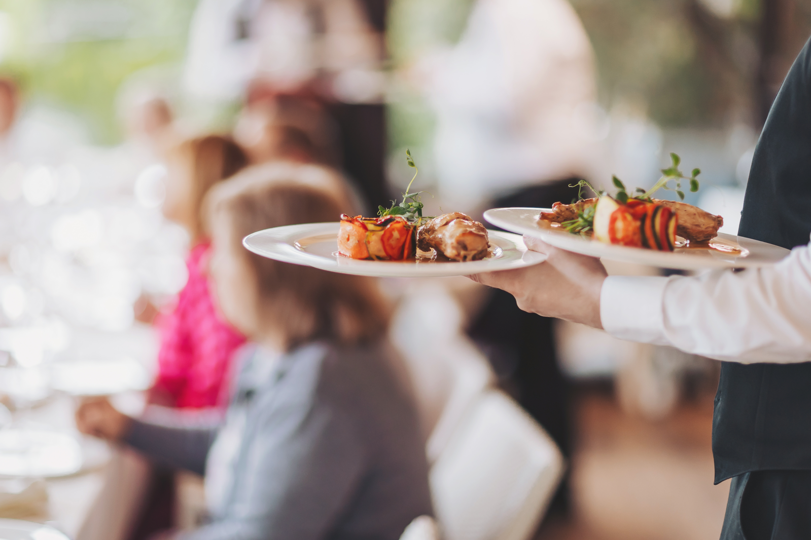 waiter bringing food out at restaurant