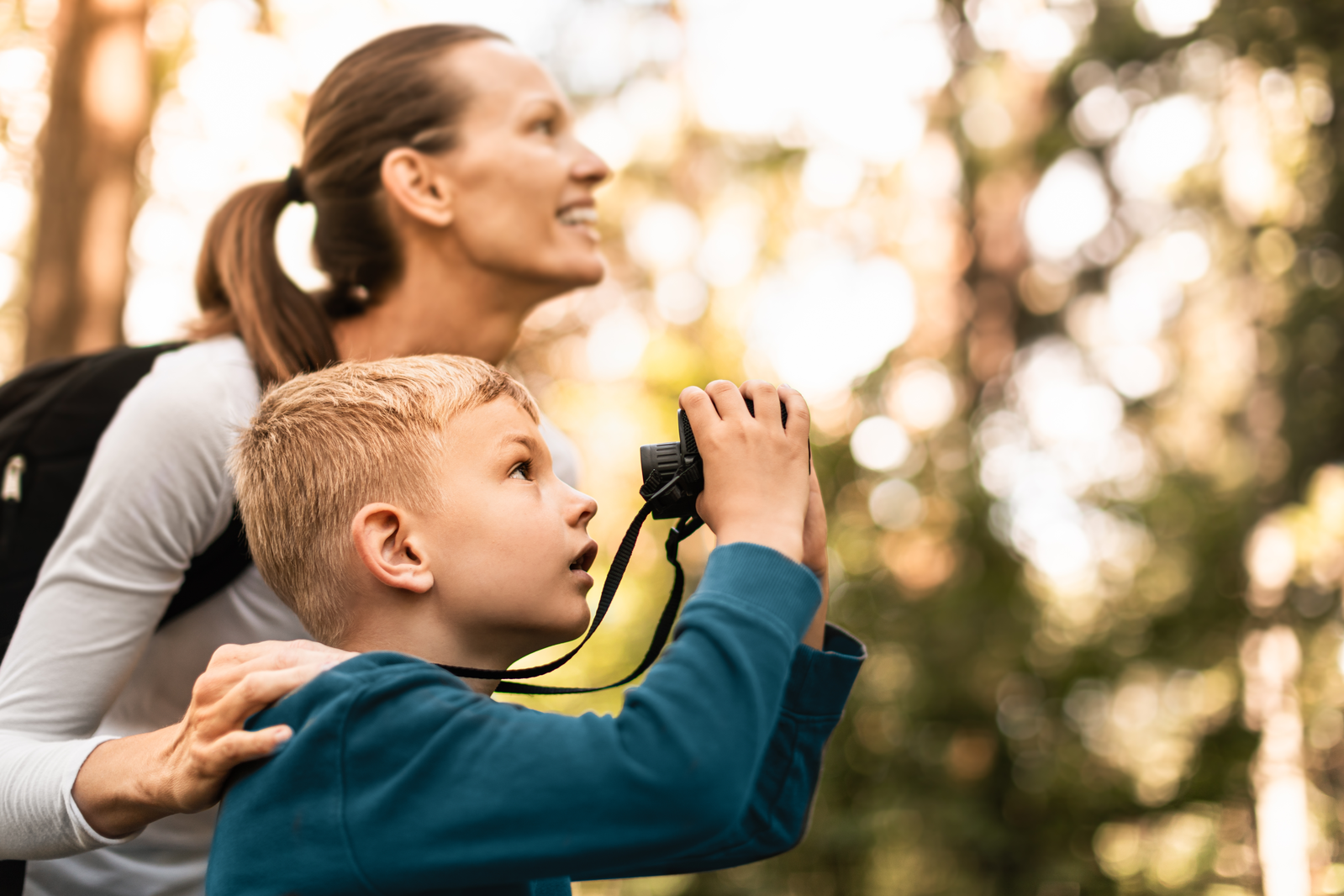 child looks through binoculars