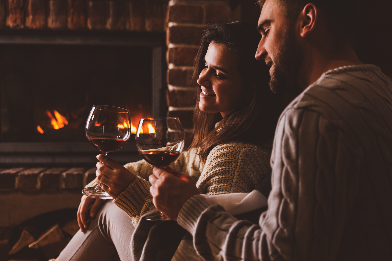 couple with wine by the fireplace