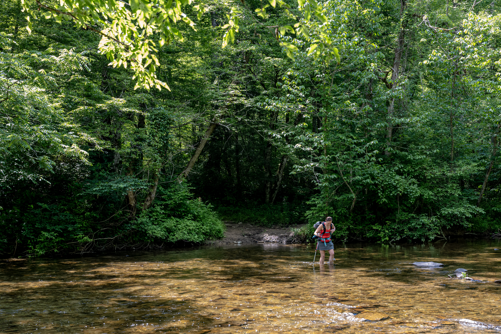 person crosses stream on foot