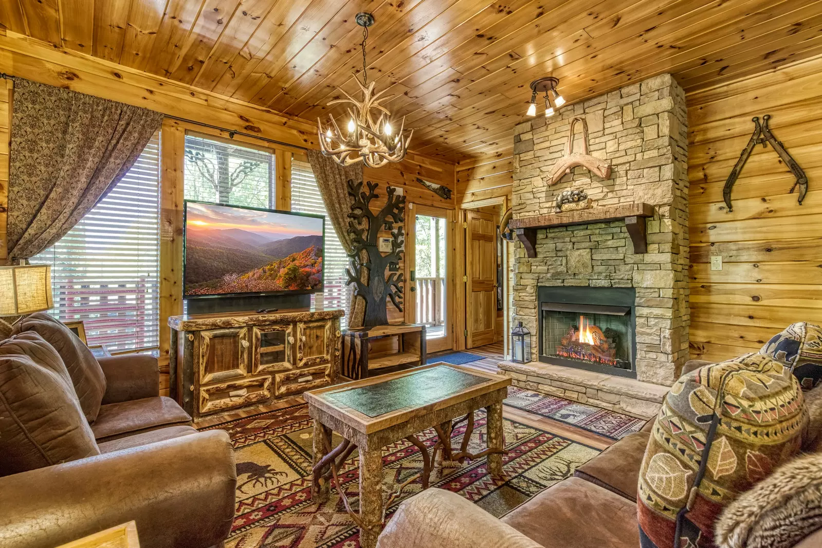 Antler Run living room with seasonal stone encased gas fireplace