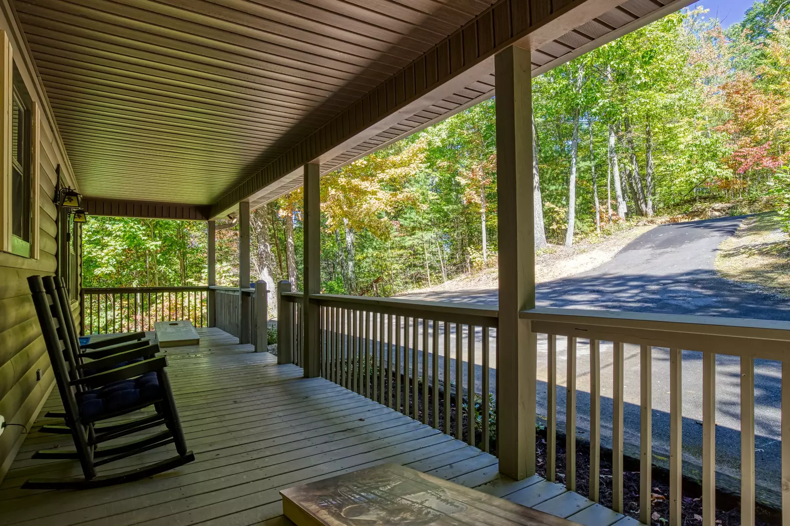 Honeymoon Hideaway covered entry deck with corn hole and rocking chairs