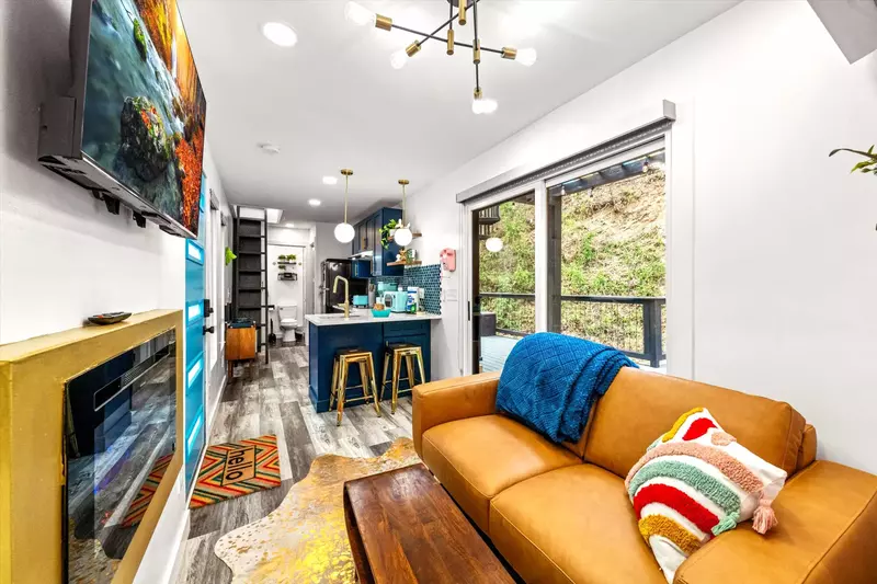 modern living room with leather sofa, gold fireplace and kitchenette