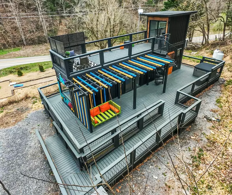 overview of container home with ramp, bed swing, outsides shower and hot tub