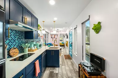 kitchen and living room view with bear decor, a vinyl record player, blue cabinets and retro decor