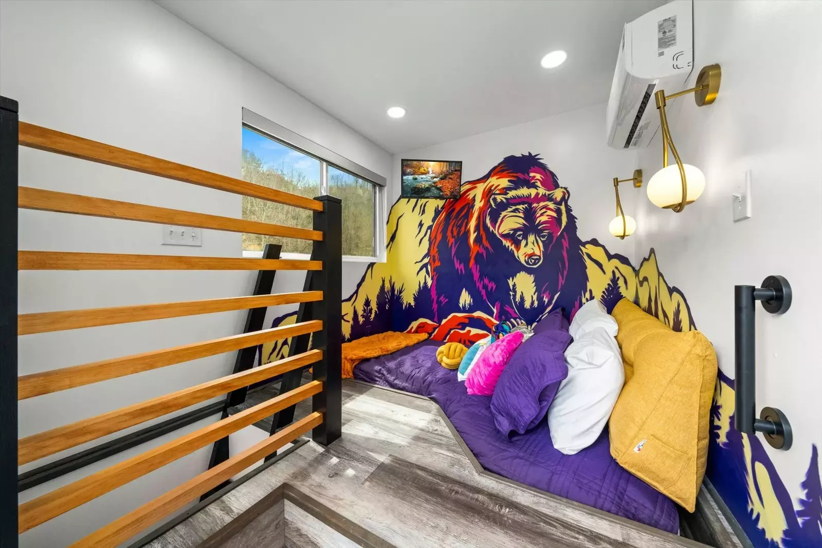 bedroom loft with cut out sunken bed, bear graffiti wall, sconces and tv