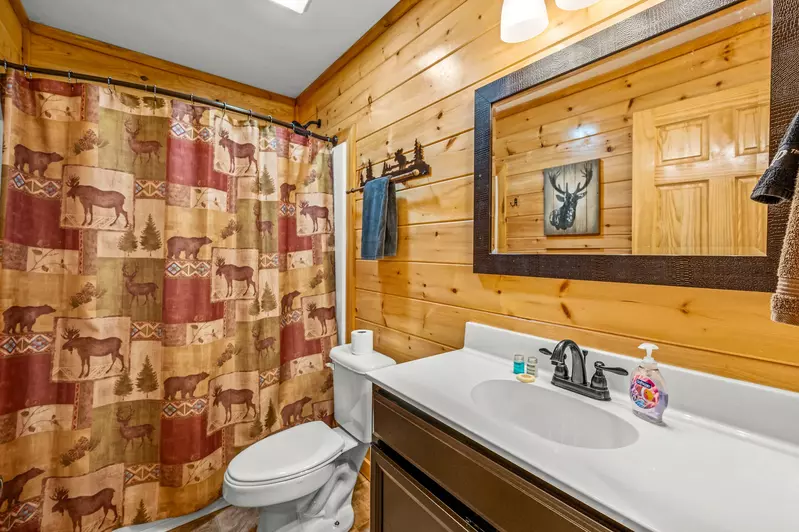 Nothin’ But a Good Time – a spacious 4-bedroom Smoky Mountain cabin rental in Sevierville featuring king bedrooms, twin bunks, hot tub, theater room, fire pit, and cozy mountain views.